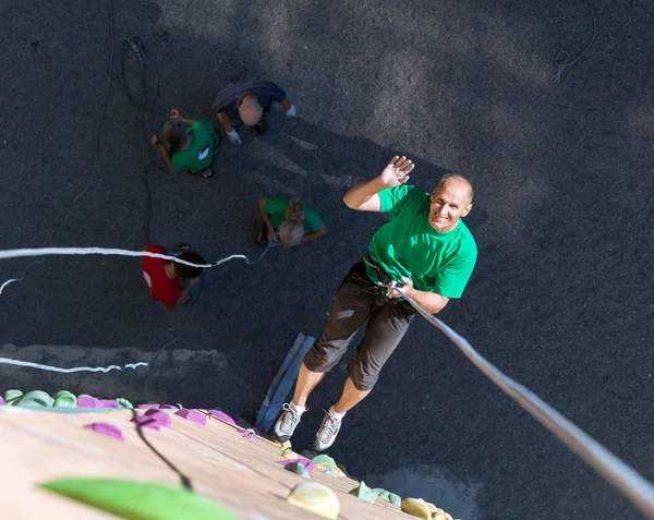 Smiling Man Descending on Rope from Top of Climbing Wall — ストック写真