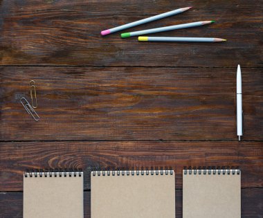 Dark Brown Wooden Desk with Sketchbooks and Pencils