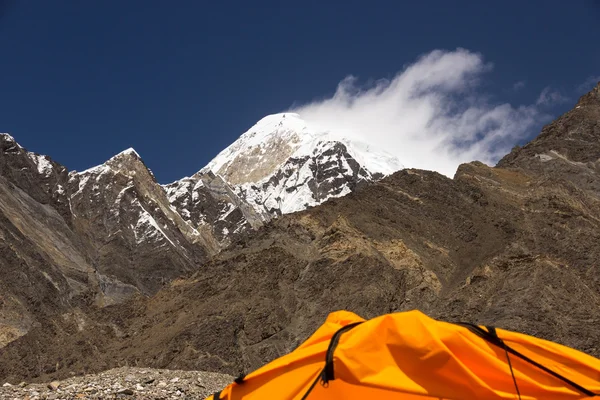 Високий гірський пік і обрізаний оранжевий намет — стокове фото