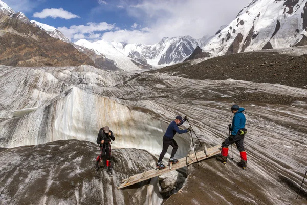 Mensen Crossing Glacier Crevasse op Wood Shaky Footbridge — Stockfoto