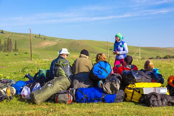 Gruppo di persone e molti zaini sul prato erboso — Foto Stock