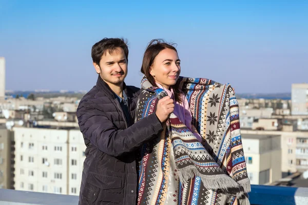 Young Man spreading Warm Wool Plaid on Shoulders of His Girlfriend — Stockfoto