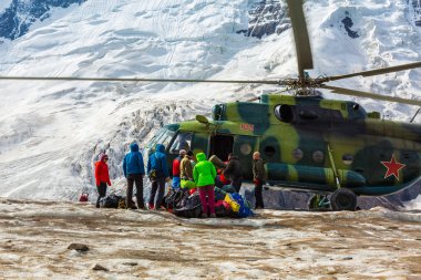 Helicopter Landing on Ice Field of Massive Glacier and People Unloading Luggage