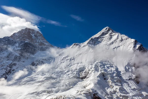 Majestuosa vista de los picos montañosos nevados de gran altitud con glaciares Rocas Nubes de nieve y cielo azul — Foto de Stock