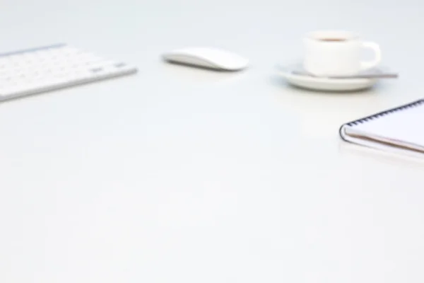 Doux fond de bureau flou avec ordinateur clavier souris tasse à café et bloc-notes vue de côté Les objets sont intentionnellement flous pour produire une image d'arrière-plan à faible contraste — Photo