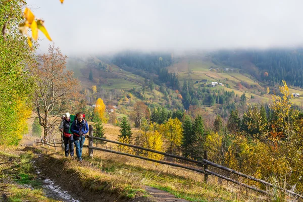 Два туристів ходіння по сільській Trail серед осінній ліс — стокове фото