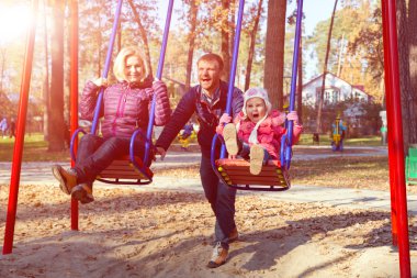 Genç neşeli aile çocuklar tahterevalli Park eğlenmek