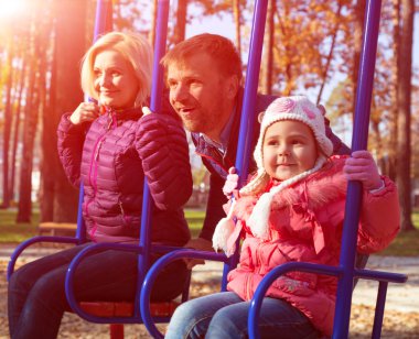 Genç neşeli aile çocuklar tahterevalli Park eğlenmek