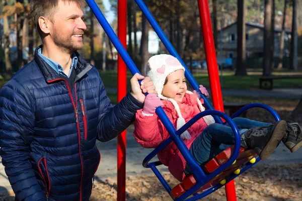 Father Riding Little Daughter on Seesaw in Autumnal Park — Stock Photo, Image