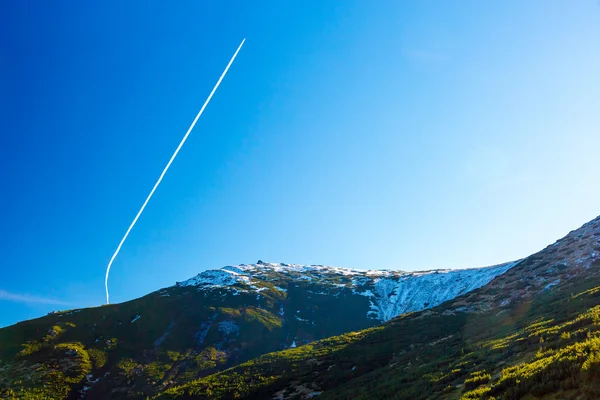 Morning Mountain View and Airplane Vapor Trail on Deep Blue Sky — стокове фото