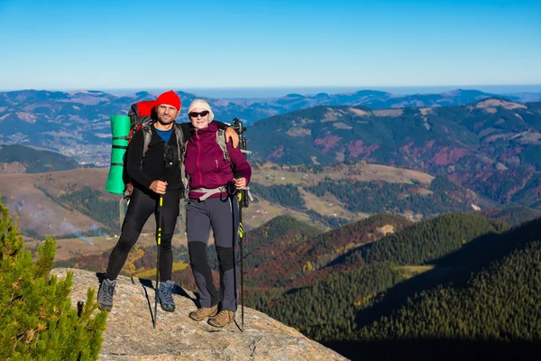 Zwei Wanderer übernachten auf hohen Felsen und Bergblick mit herbstlichem Wald — Stockfoto