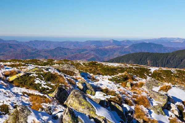 積雪の岩と黄色の草やリモートの背景に山の丘 — ストック写真
