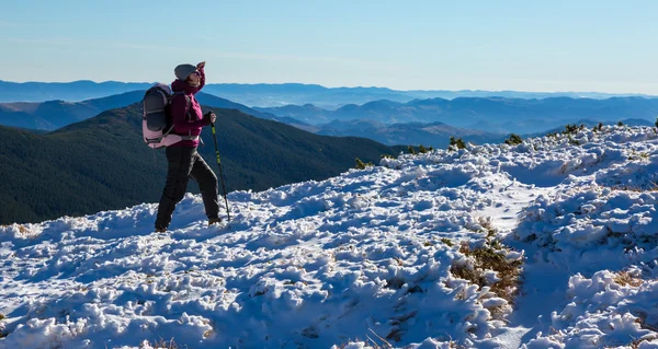 Vandrare vandring på snöiga berget sluttar bär ryggsäck — Stockfoto