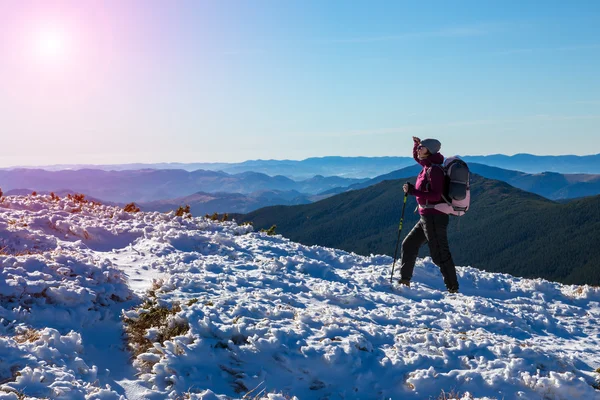 走在雪的山边坡背着背包徒步旅行者 — 图库照片