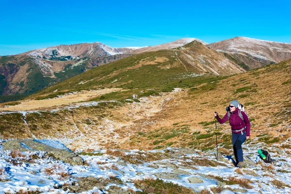 Kobiece wycieczkowicz spaceru na szlaku w górach zimą — Zdjęcie stockowe