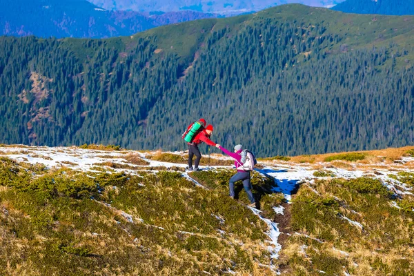 Man helping Woman to climb on steep Mountain Ridge — ストック写真