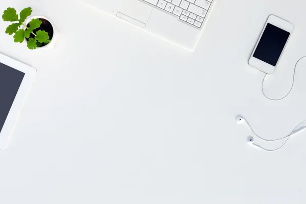 Vista superior da moderna escrivaninha branca com eletrônica branca e flor verde — Fotografia de Stock