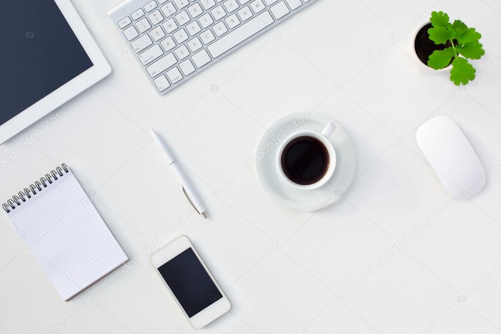 White Office Desk Table with Electronic Gadgets and Stationery Coffee Cup and Flower