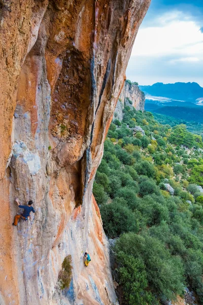 Alta roccia colorata e due scalatori in ascesa — Foto Stock