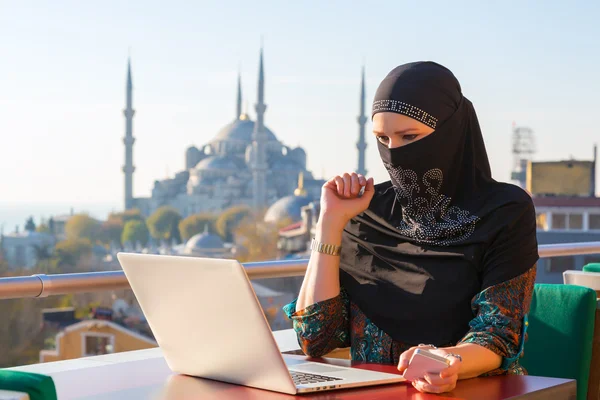 Traditioneel geklede Moslimvrouw werken op de computer — Stockfoto