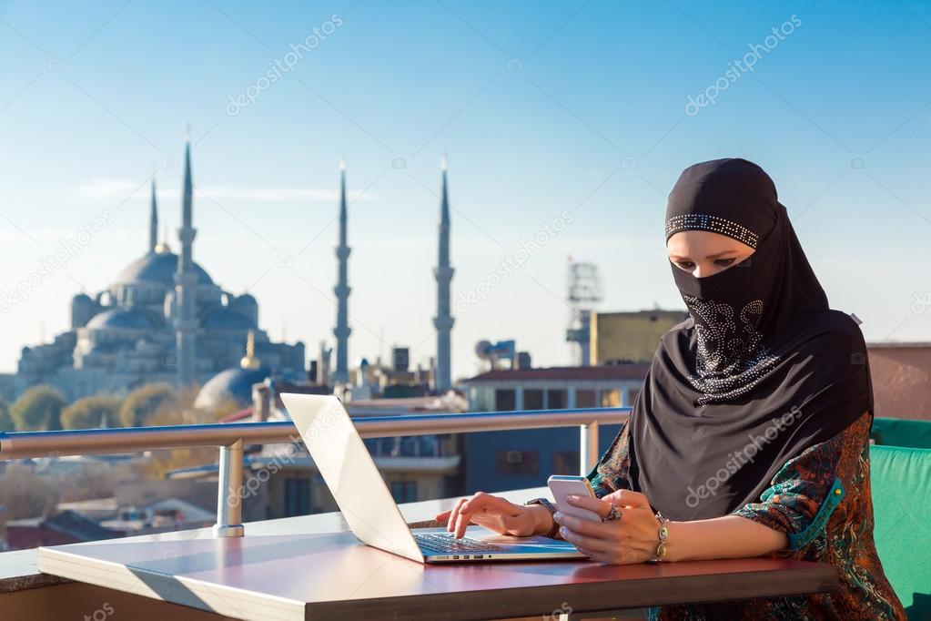 Traditionally dressed Muslim Woman working on computer