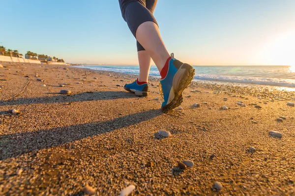 Mujer joven corriendo en la playa de arena a lo largo de Sea Surf al amanecer Zapatos Close Up — Foto de Stock