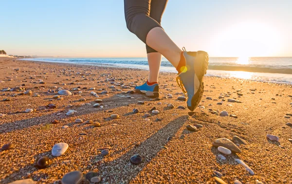 Junge Frau joggt am Sandstrand entlang der Brandung bei Sonnenaufgang Schuhe aus nächster Nähe — Stockfoto