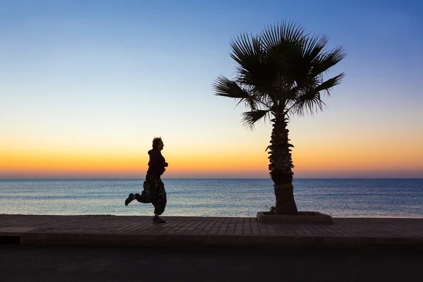 朝フィットネス海岸沿いでジョギングする若い女性 — ストック写真