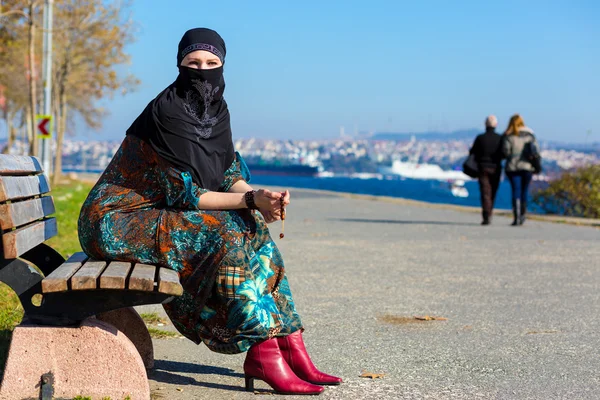 Stile musulmano vestita Lady seduta su una panchina di legno — Foto Stock