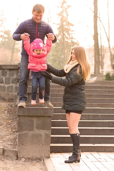 Счастливая семья с маленькой дочкой на прогулке в парке — стоковое фото