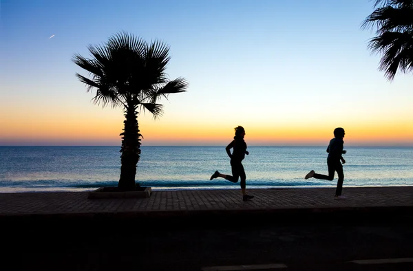Erkek ve kadın sabah Fitness yapma sahilinde koşu — Stok fotoğraf