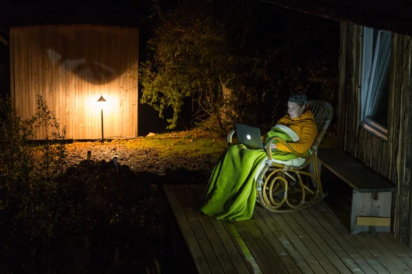 Village récréatif Bungalow et personne assise dans un fauteuil à bascule avec ordinateur — Photo