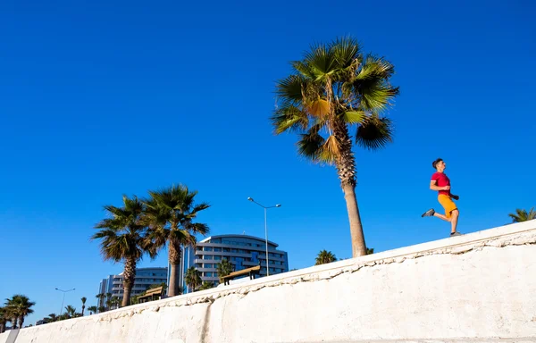 Sportif adam sahil tropikal kasaba Promenade sokak, koşu — Stok fotoğraf