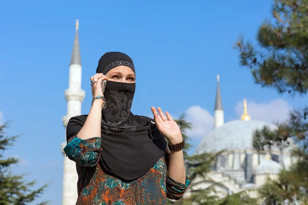 Mooie Arabische vrouw in traditionele islamitische kleding praten over de telefoon — Stockfoto