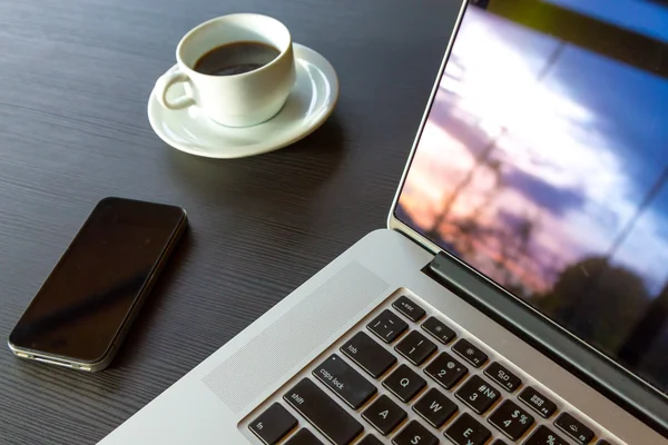 Laptop Telephone and Coffee on black wood Table Nature view reflection — Stock Photo, Image