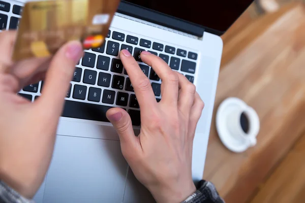 Mãos da pessoa que introduz dados do cartão de crédito no portátil — Fotografia de Stock