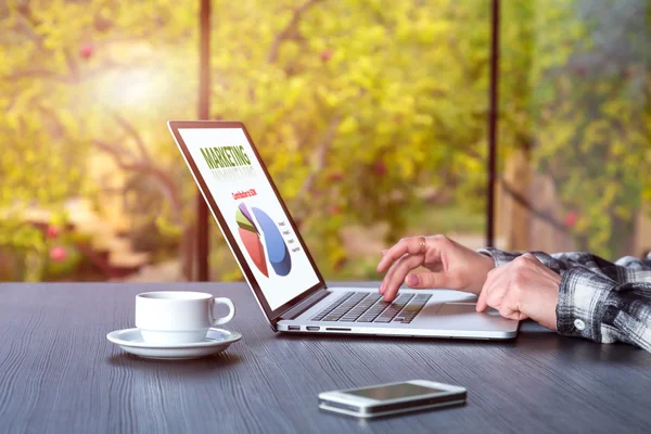 Persoon die werkt op houten bureau op computer koffie telefoon — Stockfoto