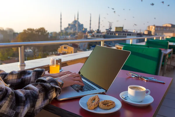 Robocze śniadanie osoba działa na laptopie w Cafe Terrace — Zdjęcie stockowe