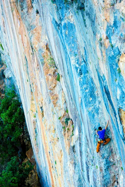 Brillante luminoso naranja azul Patrón de roca y escalador — Foto de Stock