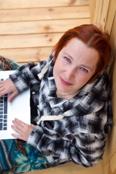 Mulher sentada no chão de madeira natural trabalhando no computador — Fotografia de Stock