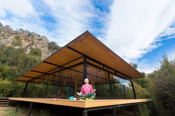 Person doing Yoga Exercise on wooden Terrace of rural Cabin — Stock Photo, Image