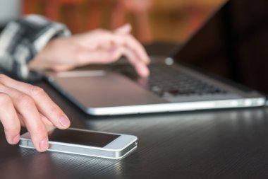 Telefon ekran dokunaklı ve bilgisayarda çalışan eller