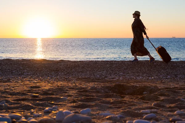日の出オーシャン ビーチを歩いて女性の旅行者 — ストック写真