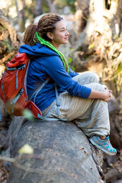 Roztomilá dívka sedící na stonek Les těší teplé sluníčko — Stock fotografie
