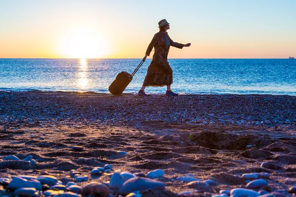 日の出オーシャン ビーチを歩いて女性の旅行者 — ストック写真
