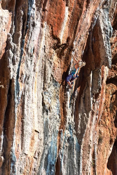 Escalador de roca joven ascendente empinado colorido rocoso pared plomo escalada — Foto de Stock