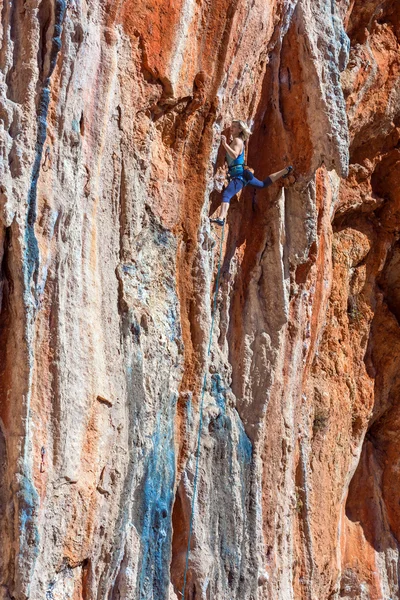 Kobieta alpinista prowadzić wspinaczka naturalnych skał — Zdjęcie stockowe