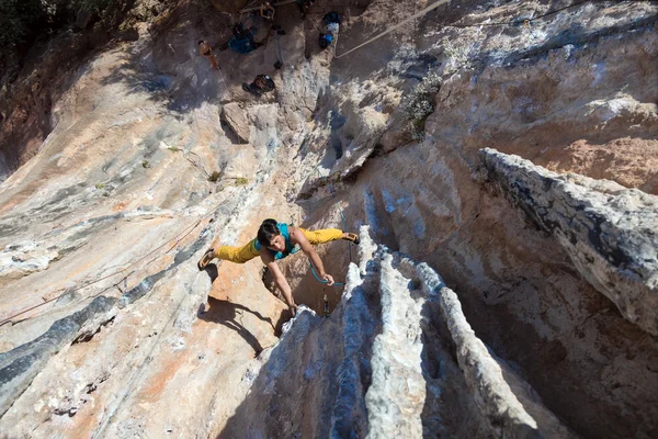 Зрелый мужчина экстремальный альпинист висит на скале необычной формы — стоковое фото