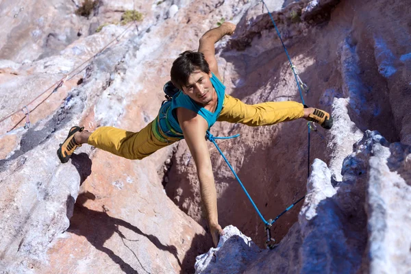 Sonriente macho extremo escalador colgando en inusual forma de roca — Foto de Stock