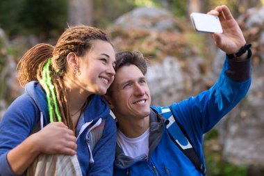 Baba ve kızı gülümseyen ve cep telefonu ile fotoğraf çekme